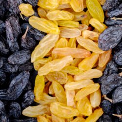 background of dried fruits black and yellow raisins top view